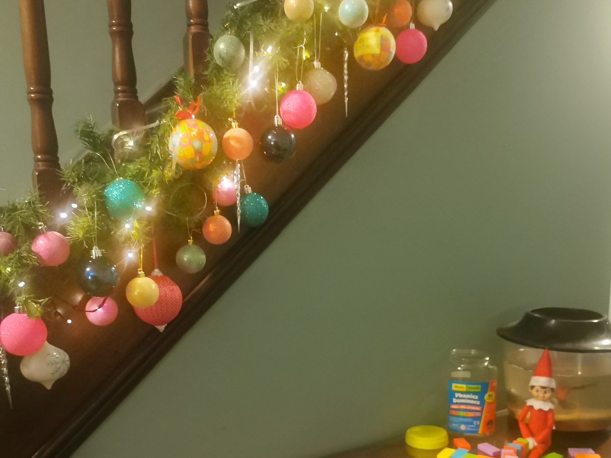 Elf positioned to tip first domino in a lined chain-reaction path.