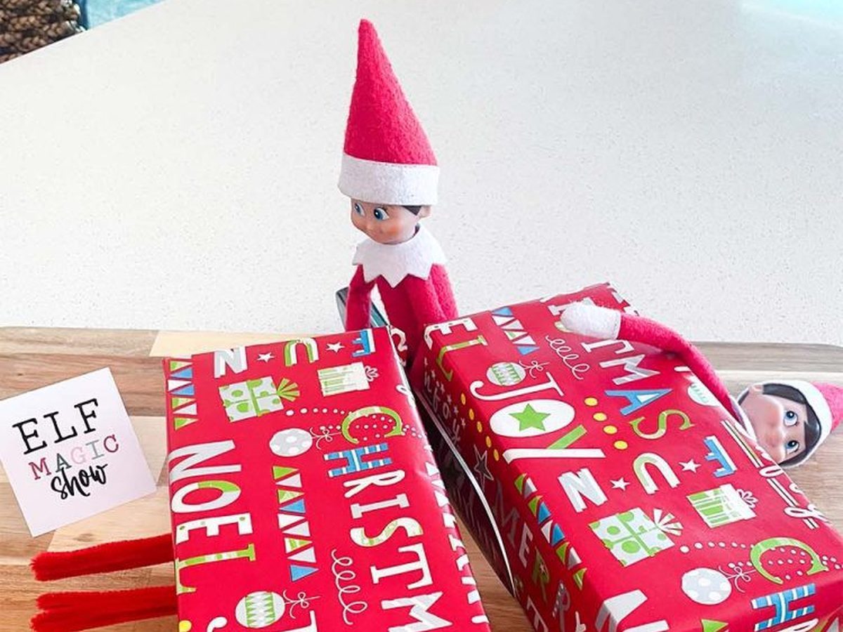 One elf with knife cutting another elf in wrapped boxes, magic trick illusion setup.