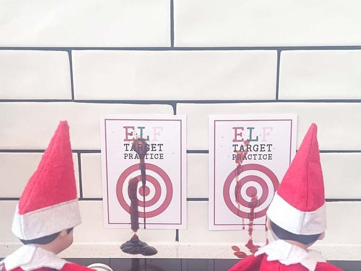 Two elves squirt sauce bottles at target practice signs on white background.