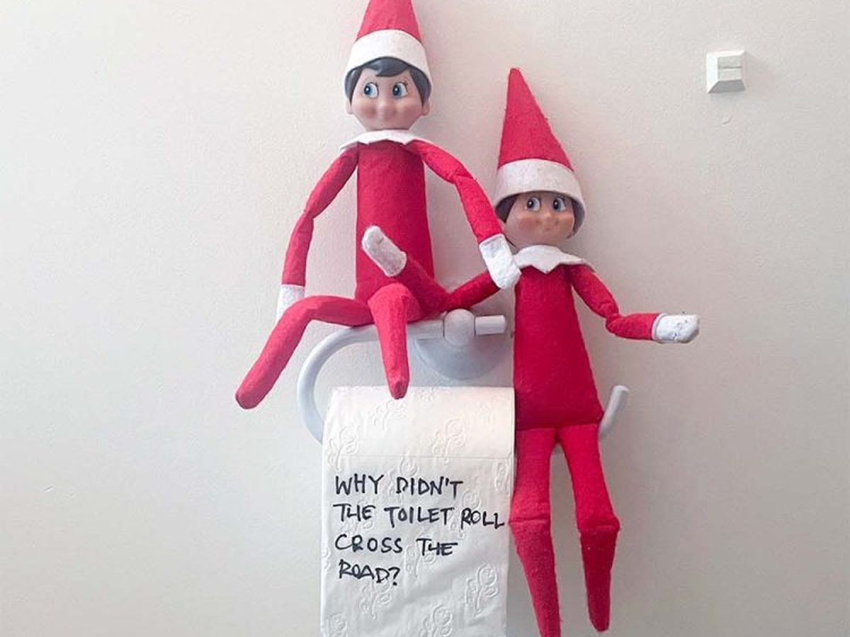 Two elves sitting on unrolled toilet paper with handwritten joke text visible.