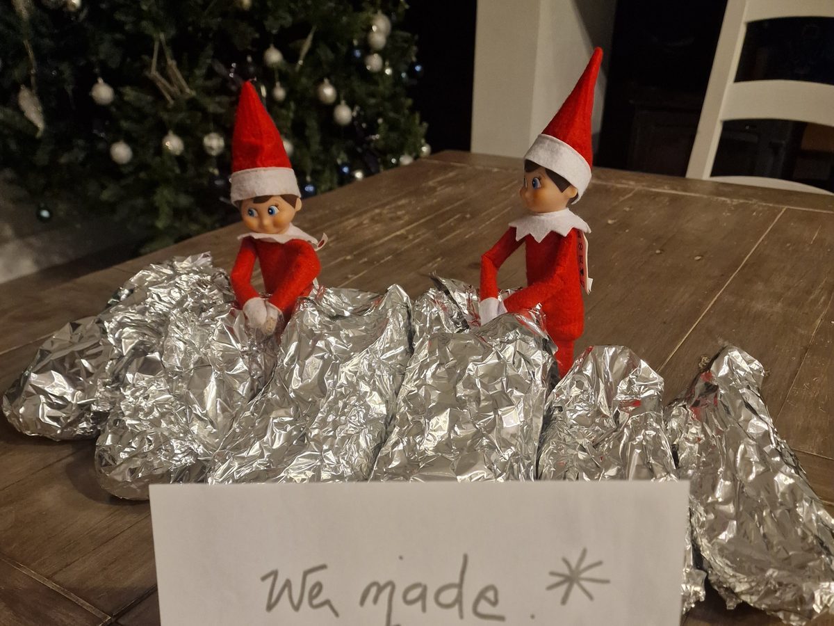 Elf covers shoes in aluminum foil as part of creative shoe-shining prank.