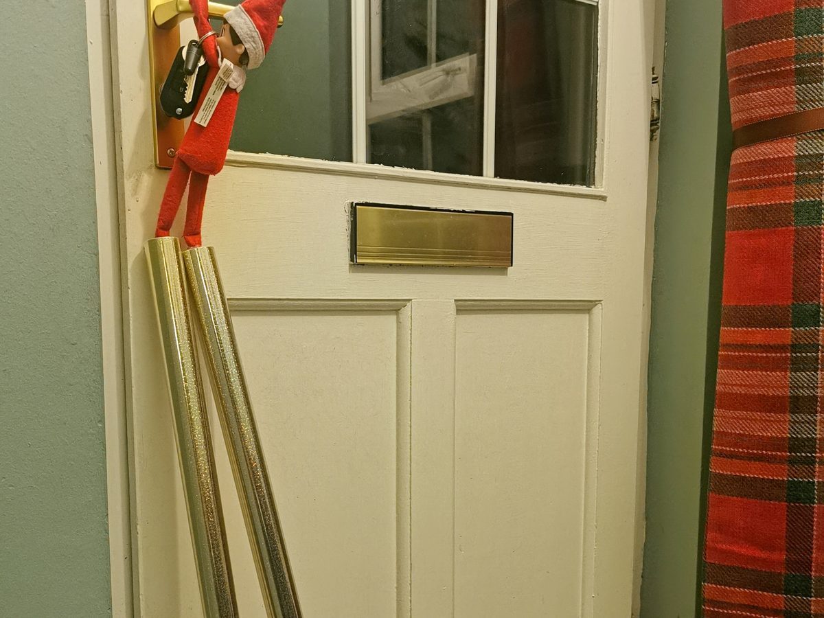 Elf tied with rope attempting escape using toy car as anchor point.