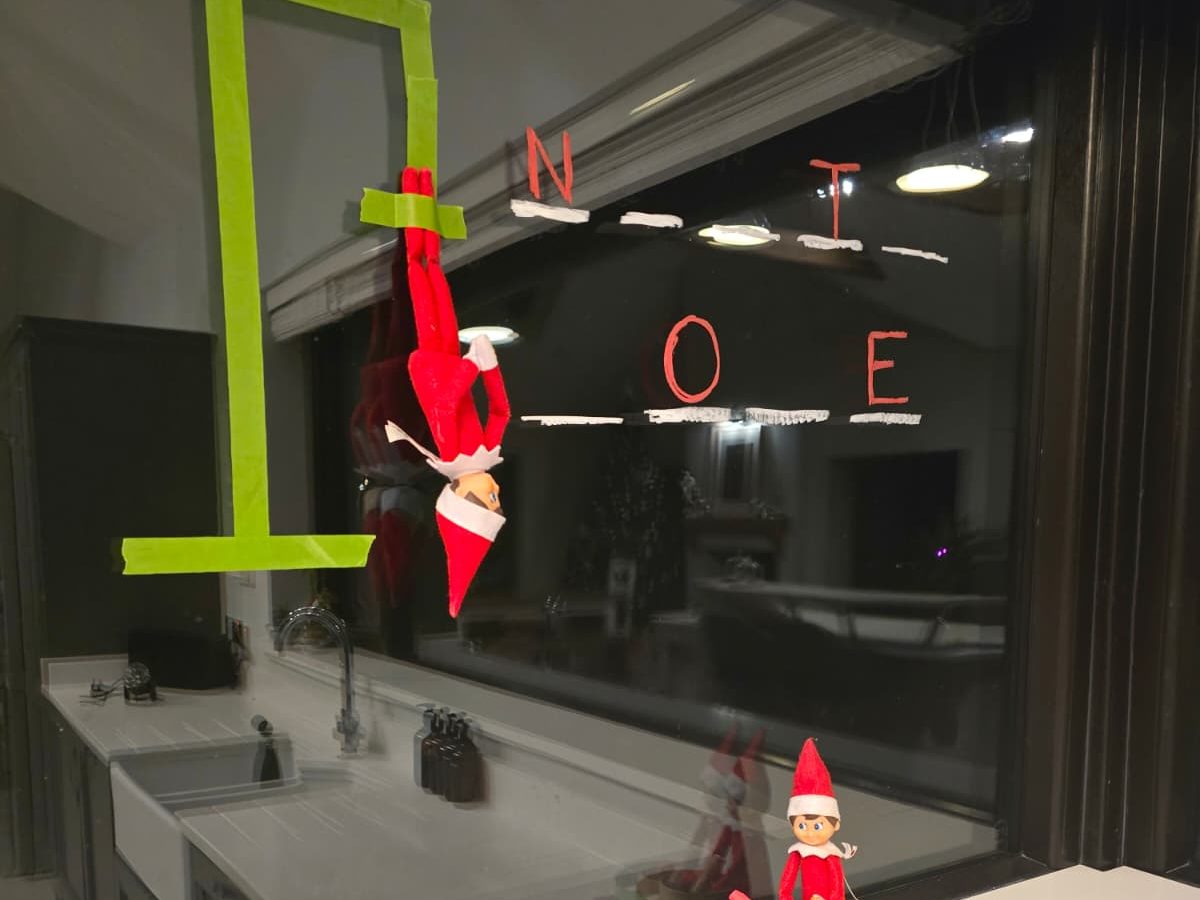 Elves positioned opposite each other playing hangman game with partially revealed word puzzle.