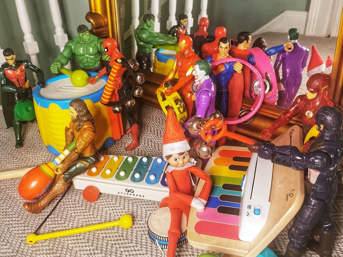 Elf conducting toy musical instruments as orchestra conductor with baton.